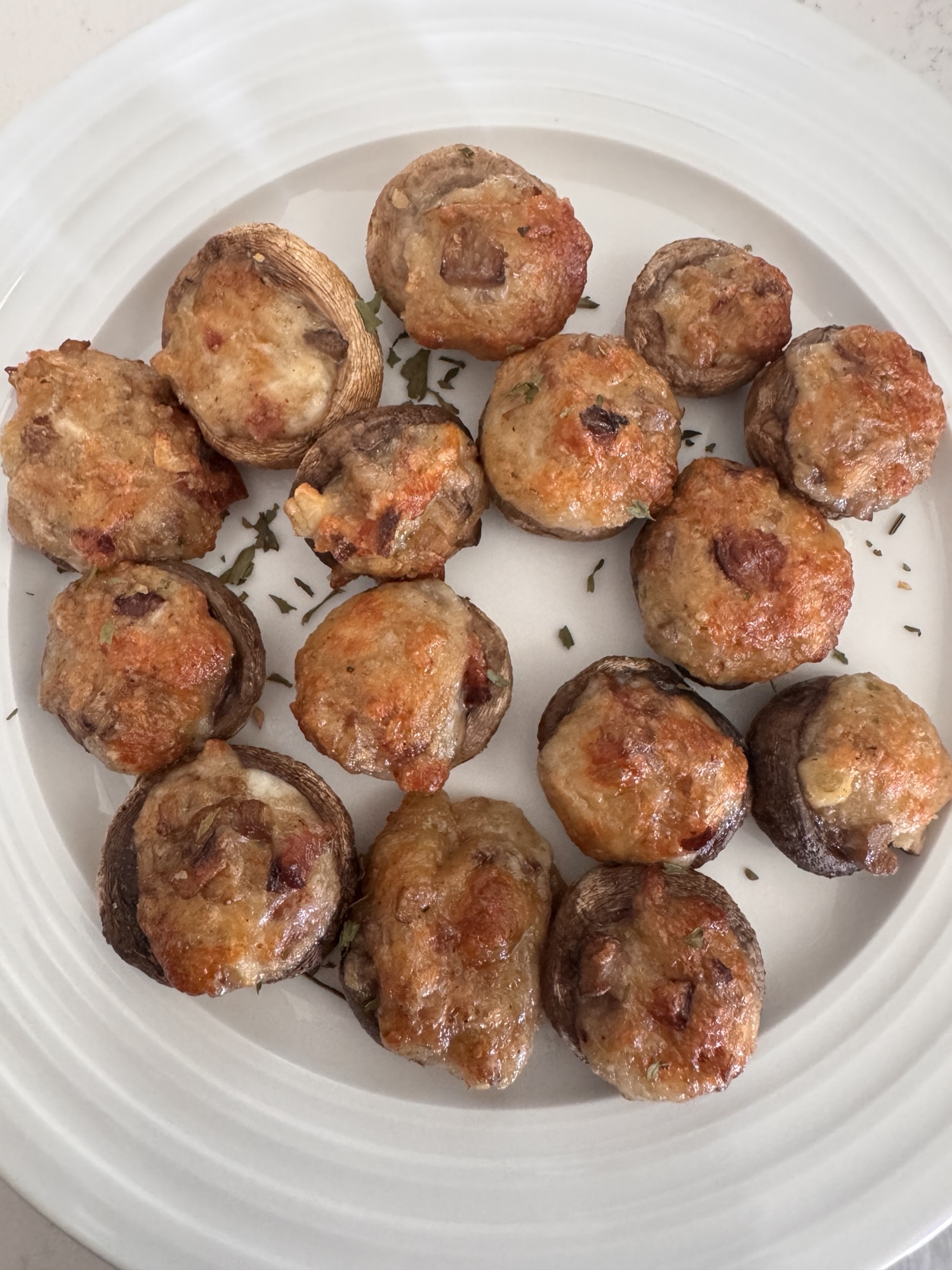 Cheese and bacon stuffed mushrooms on a white plate